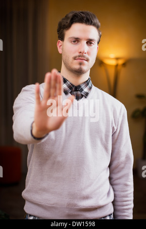 Beau jeune homme seerious faisant stop avec sa main avec une expression sévère. Banque D'Images