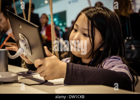 Barcelone, Espagne. 25 février 2014 : Une petite fille qui fréquentent le Mobile World Congress 2014 joue à des jeux vidéo sur le Nokia Lumia Pad. Credit : matthi/Alamy Live News Banque D'Images