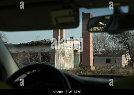 Milovice, République tchèque. 25 février 2014. Des bâtiments abandonnés vu à travers un pare-brise d'une voiture dans le domaine de la base militaire soviétique à Milovice, situé à environ 40 km de Prague, République tchèque. Ruines de l'ancienne base militaire soviétique en Milovice doivent être démolis au cours des quelques prochains mois pour faire place à de nouveaux bâtiments. La base a été abandonnée depuis plus de vingt ans, depuis le départ des troupes soviétiques de la Tchécoslovaquie en 1991. Maintenant la base militaire abandonnée survit pour le dernier jours. Banque D'Images