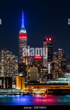 Empire State Building de nuit. Haut de la gratte-ciel emblématique affiche les couleurs du drapeau américain, bleu-blanc-rouge, en l'honneur de Banque D'Images