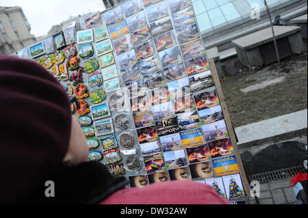 (140226) -- KIEV, 26 février 2014 (Xinhua) -- Une femme regarde sur souvenirs avec des scènes d'affrontements sur la place de l'Indépendance à Kiev, capitale de l'Ukraine, le 25 février 2014. (Xinhua/Dai Tianfang) Banque D'Images