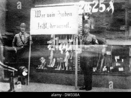 Des membres de l'sa (Sturmabteilung, l'aile paramilitaire du parti nazi) se tiennent devant un magasin juif tenant une affiche qui indique : « Whoever Eat des Juifs mourra d'une mort misérable ! » À Berlin, avril 1933. Sous le slogan 'Allemands! Défendez-vous ! N'achetez pas auprès des Juifs!" Un riche boycott des boutiques, médecins et avocats juifs a commencé le 01 avril 1933 . La campagne antisémite a été organisée par le Comité central pour la défense de l'atrocité juive et l'agitation du boycott. Fotoarchiv für Zeitgeschichte / PAS DE SERVICE DE FIL Banque D'Images