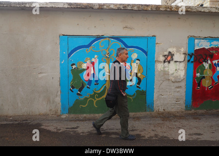 Homme marchant le long de la rue Israël Safed murale avec en arrière-plan Banque D'Images