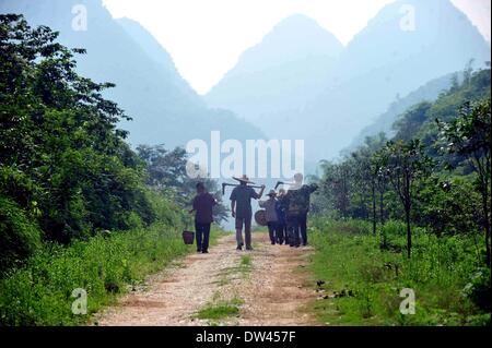 (140227) -- RONG'AN, 27 février 2014 (Xinhua) -- les villageois de retourner à la maison après une journée de travail dans Tongban Village, Rong'an County, Chine du Sud, région autonome Zhuang du Guangxi, le 15 mai 2013. Tongban, village situé dans les régions montagneuses de Rong'an de la région autonome Zhuang du Guangxi, utilisé pour être un petit village avec plus de 100 habitants qui vivaient par la plantation de pruniers. Depuis les années 1990, la jeune génération d'Tongban a renoncé à la vie et il y a commencé à travailler dans les villes. Comme de plus en plus de jeunes personnes hors de la ville, le village a été animé une fois sur le déclin w Banque D'Images