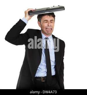 Pleurer businessman s'abritant sous son ordinateur portable blubbing le coeur dans la douleur, le haut du corps portrait isolated on white Banque D'Images