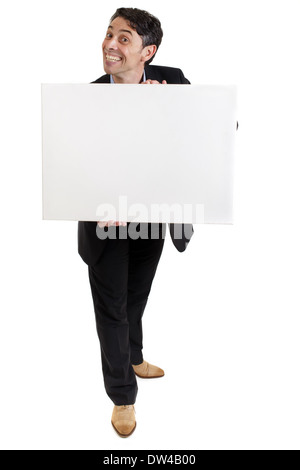 Smart, middle-aged businessman avec un sourire hypocrite au fromage rugueux holding a blank panneau blanc dans ses mains avec copyspace Banque D'Images