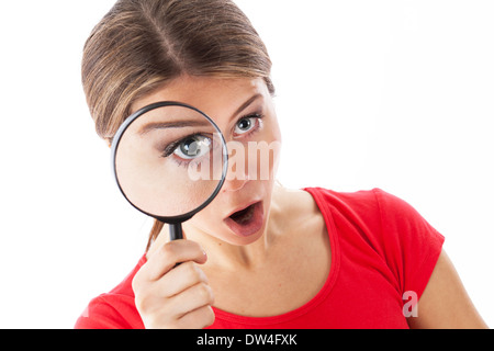 Fille à travers une loupe et à la surprise, isolated on white Banque D'Images