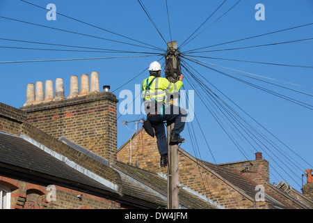 Télécommunications ingénieur travaillant sur un transparent les communications téléphoniques entre les pôles des maisons mitoyennes à Londres, Royaume-Uni Banque D'Images