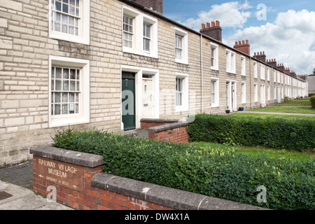 Une rangée de cottages dans le chemin de fer historique préservé GWR village de Swindon, Wiltshire et le signe pour le musée Banque D'Images