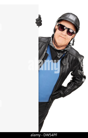 Mâle mature biker debout derrière panneau vierge Banque D'Images