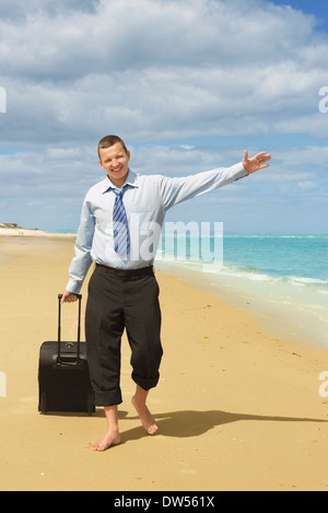 Businessman walking sur la plage le premier jour de vacances Banque D'Images