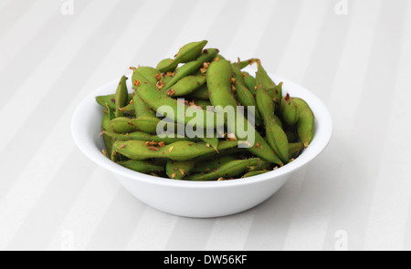 Edamame cuites et épicées - gousses de soja épicé dans un bol blanc. Banque D'Images