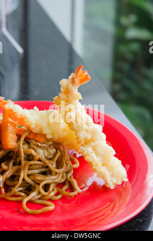 Nouilles sautées avec légumes et crevettes Frits sur un plat rouge Banque D'Images