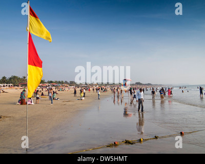 L'Inde, Goa, Baga, touristes indiens sur la plage, entre les drapeaux de baignade sécuritaire de sauveteur Banque D'Images