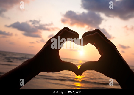 Coeur de mains de couple sur la plage Banque D'Images