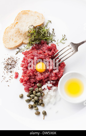 Tartare de boeuf aux câpres et oignons frais sur fond blanc Banque D'Images