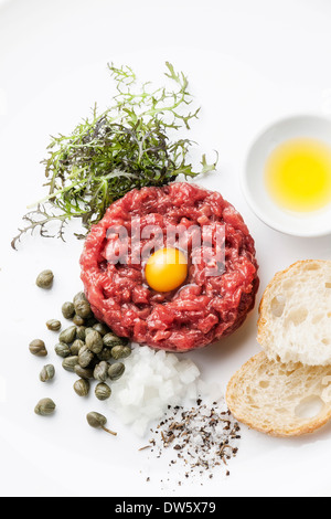 Tartare de boeuf aux câpres et oignons frais sur fond blanc Banque D'Images