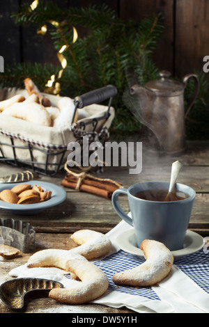 Sugar cookies faits maison servis crescent avec tasse de thé, accessoires de mode, des amandes et des épices plus vieille table en bois Banque D'Images