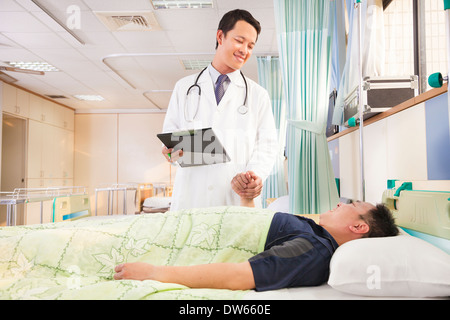 Smiling doctor holding patient part pour l'encourager dans le quartier Banque D'Images