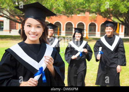 Jolie asian college graduate détient un diplôme avec ses camarades Banque D'Images