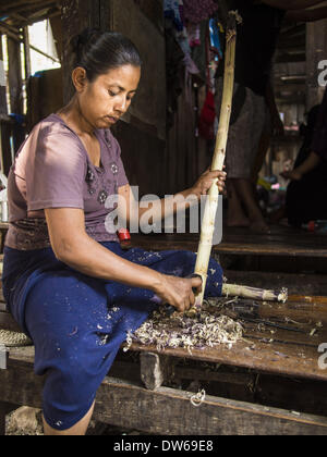 Mae Sot, Tak, en Thaïlande. 28 Février, 2014. Une femme birmane épluche la canne à sucre en face de sa maison. Elle vend des jus de canne à sucre dans le marché à Mae Sot. Mae Sot, sur le Thai-Myanmer (Birmanie) frontière, a une très grande population de migrants birmans. Certains sont des réfugiés qui ont quitté le Myanmar pour échapper à l'agitation civile et la persécution politique, d'autres sont ''réfugiés économiques'' qui sont venus en Thaïlande à la recherche d'un emploi et de meilleures opportunités. © Jack Kurtz/ZUMAPRESS.com/Alamy Live News Banque D'Images