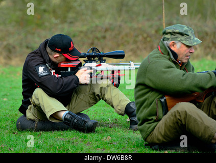 L'homme à tirer sur la cible de compétition de l'association sur le terrain avec carabine à air équipé de la télémétrie étendue télescopique.Essex UK Banque D'Images