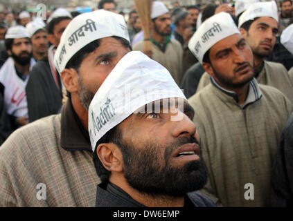 Srinagar, au Cachemire. 1er mars 2014. Les partisans du Cachemire indien d'AAM Admi, homme du commun, (partie), d'entendre le discours du candidat de parti Raja Muzaffar Bhat lors d'un road show en vue de la prochaine campagne des élections parlementaires, à Srinagar, Raja fera face à deux piliers, le Dr Farooq Abdullah de Conférence nationale et Tariq Hameed Qarra de PDP. Mandat du PAA à Dr Bhat a annoncé à une réunion présidée par le président de LS élections, Gopal Rai, à New Delhi. La partie prétend qu'il a enregistré 10 lakh membres à contrôler les indiens du Cachemire. Credit : Shafat Sidiq/NurPhoto ZUMAPRESS.com/Alamy/Liv Banque D'Images