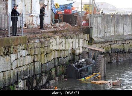 Portland, UK. 1er mars 2014. Un sauvetage spectaculaire d'un digger pilote après son véhicule a chuté de 15 pieds dans le port de Portland cet après-midi (samedi) l'homme a été évacué par hélicoptère des garde-côtes à Southampton après l'hôpital il a été sauvé par les gardes-côtes, les sapeurs-pompiers et les collègues. Dorset les policiers enquêtent sur l'incident et ont bouclé le secteur. 06Th Mars, 2014 Photo par Geoff Moore/Dorset Media Service/Alamy Live News Banque D'Images