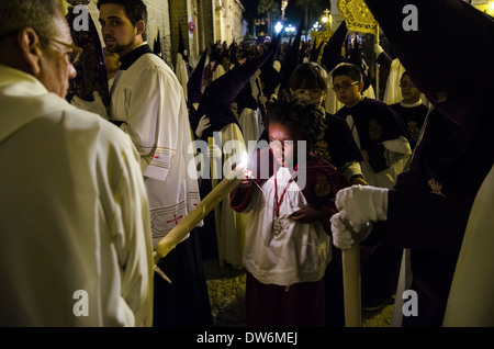 Un acolyte de la confrérie de "La Candelaria' allumer une bougie. Dans la région de Jerez, en Espagne. Banque D'Images