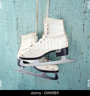 Paire de patins à glace pour femmes blanc sur bleu vintage background - féminin concept sports d'hiver Banque D'Images