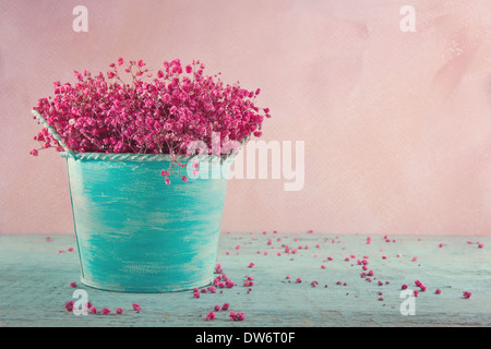 La respiration du bébé rose fleurs séchées dans un vase bleu sur fond vintage en bois Banque D'Images