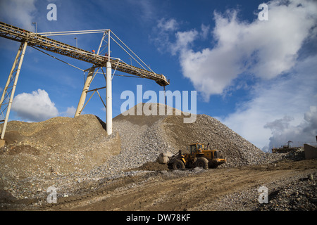 Le minerai de cuivre se situe à l'extrémité d'une courroie de transport pour une réserve à ciel ouvert dans une grande mine de cuivre et d'or Banque D'Images