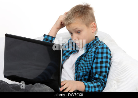 Beau Garçon de l'adolescence avec un ordinateur portable sur la table Banque D'Images