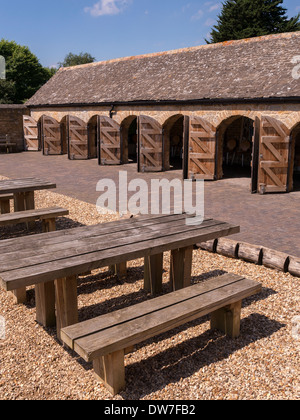 Tables de pique-nique et de ligne de arch des portes dans une écurie en pierre ancienne, Fineshade Woods, Corby, Northamptonshire, England, UK Banque D'Images