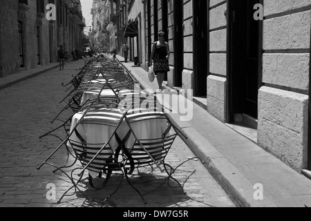 Tables et chaises empilées dans rue latérale dans Habana Vieja, Cuba Banque D'Images