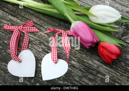 Deux coeurs le Jour de Valentines avec tulipes de couleur sur fond de bois Banque D'Images