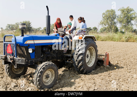 Les agriculteurs indiens de la conduite du tracteur avec la famille et de parler Banque D'Images