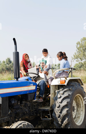 Les agriculteurs indiens de la conduite du tracteur avec la famille et de parler Banque D'Images