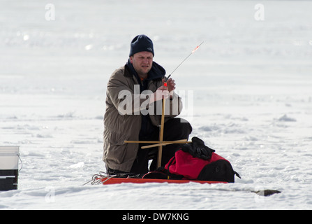 L'homme la mise en place d'engins de pêche sur glace sur le lac Eagle, l'Acadia National Park, Maine Banque D'Images