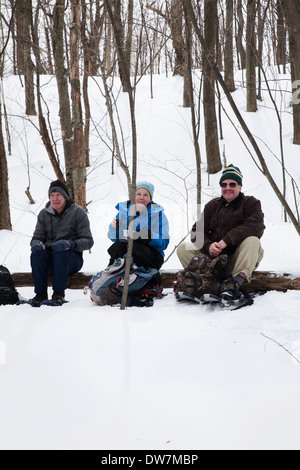 Les randonneurs d'hiver se détendre et se reposer le long d'une piste couverte de neige sur le mont Greylock, Adams, MA. Banque D'Images