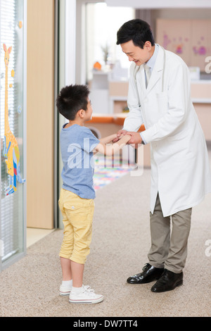 Doctor talking to petit garçon à l'hôpital Banque D'Images