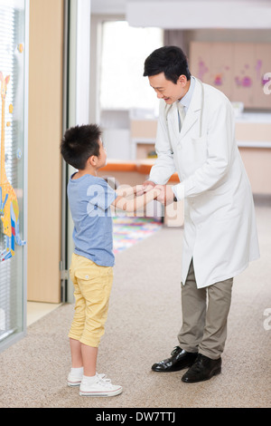 Doctor talking to petit garçon à l'hôpital Banque D'Images