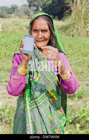 Vieille Femme indienne 1 fermes permanent avec mobile Banque D'Images