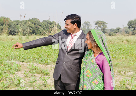 Businessman showing à old woman in farm Banque D'Images