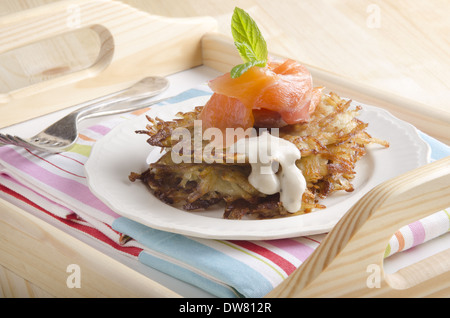 Pommes de terre rissolées et de saumon fumé à la menthe sur une plaque Banque D'Images