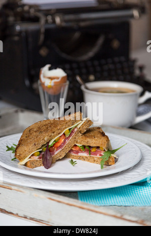 Petit déjeuner de pain grillé, un œuf et une tasse de thé sur fond de machines à écrire Banque D'Images