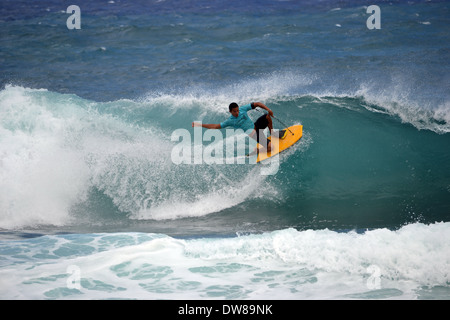 Bodyboarder sur son genou le surf une vague sur une plage de sable, à l'Est Oahu, Hawaii, USA Banque D'Images