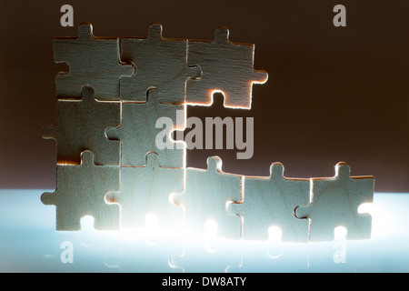 Puzzle en bois et l'éclairage de l'arrière-plan. Pièces empilées verticalement. Banque D'Images