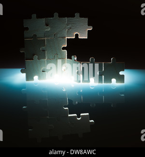 Puzzle en bois et l'éclairage de l'arrière-plan. Pièces empilées verticalement. Banque D'Images