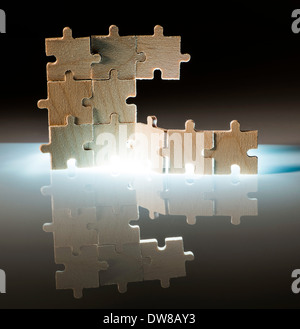 Puzzle en bois et l'éclairage de l'arrière-plan. Pièces empilées verticalement. Banque D'Images